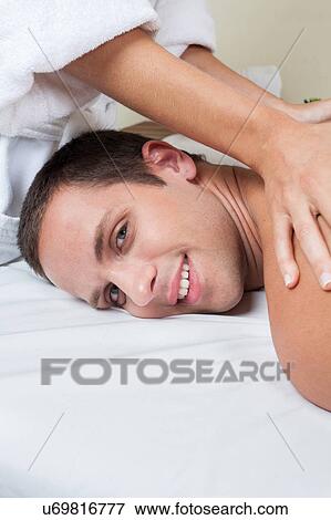 Stock Photo - Happy man receiving a massage. Fotosearch