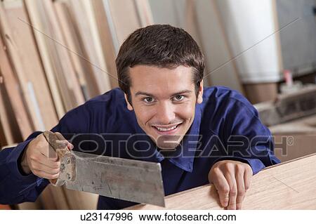 Happy man using a saw View Large Photo Image Stock Photograph - Happy man using a saw. Fotosearch