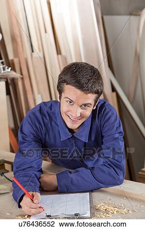 Happy man writing in his workshop View Large Photo Image Stock Image - Happy man writing in his workshop. Fotosearch