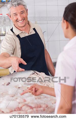 Stock Photo - Happy seller of fish . Fotosearch