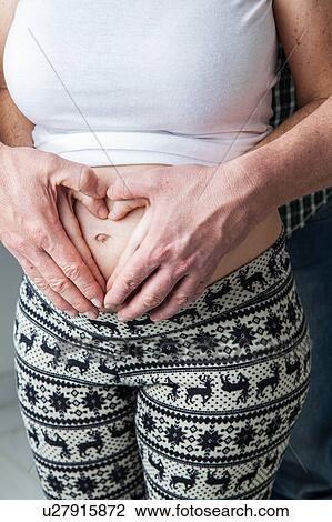 Stock Image - Heart with hands on belly. Fotosearch