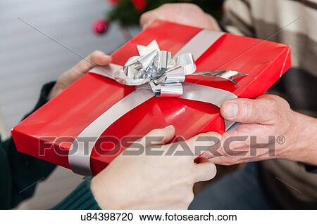 Holding a red gift View Large Photo Image Stock Image - Holding a red gift. Fotosearch