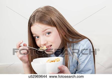 Little girl eating cereal in the breakfast View Large Photo Image Picture - Little girl eating cereal in the breakfast. Fotosearch