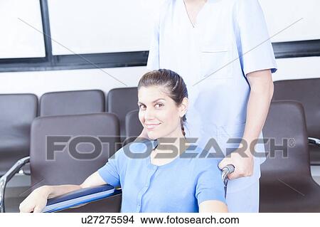 Picture - Male nurse helping a woman. Fotosearch