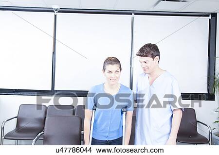 Picture - Male nurse helping a woman. Fotosearch