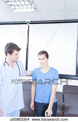 Picture - Male nurse helping a woman. Fotosearch