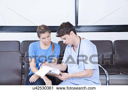 Stock Image - Male nurse helping a woman. Fotosearch