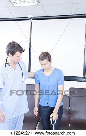 Stock Photo - Male nurse helping a woman. Fotosearch