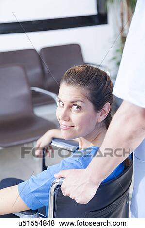 Stock Photo - Male nurse helping a woman. Fotosearch