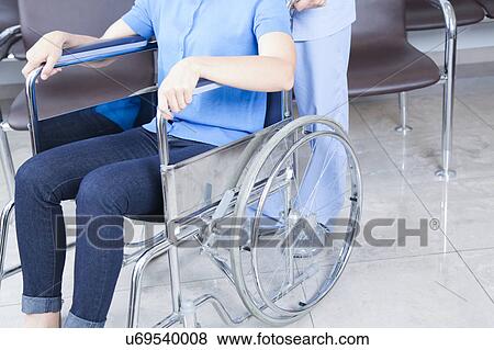 Stock Photo - Male nurse helping a woman. Fotosearch