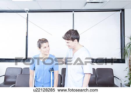 Stock Photography - Male nurse helping a woman. Fotosearch
