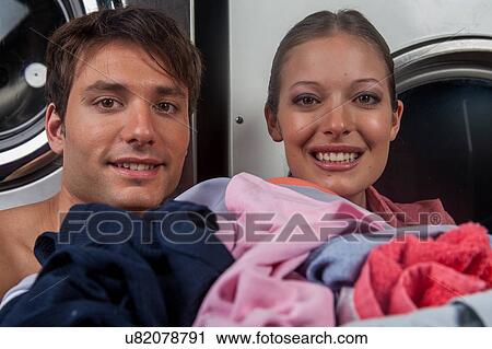 Man and woman looking at camera in the laundry View Large Photo Image Stock Image - Man and woman looking at camera in the laundry. Fotosearch