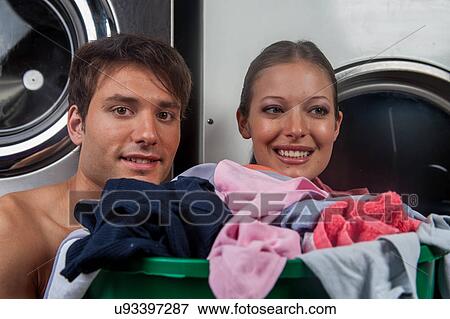 Stock Photo - Man and woman looking at camera in the laundry. Fotosearch