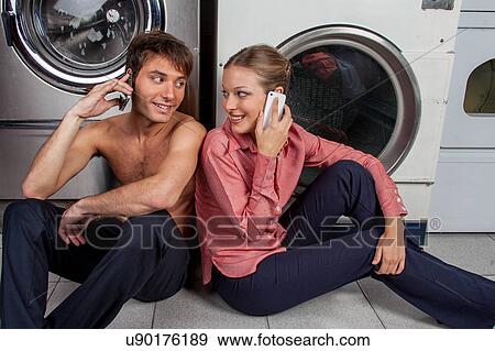 Stock Photo - Man and woman talking on the phone in the laundry. Fotosearch