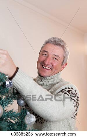 Stock Photography - Man assembling the christmas tree. Fotosearch