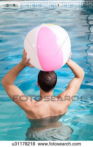Stock Photo - Man back playing with a inflatable ball. Fotosearch