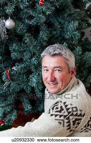 Man beside the christmas tree View Large Photo Image Stock Image - Man beside the christmas tree. Fotosearch