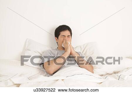Stock Image - Man blowing his nose. Fotosearch