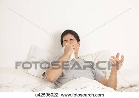 Stock Image - Man blowing his nose. Fotosearch