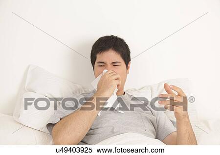 Stock Photography - Man blowing his nose. Fotosearch