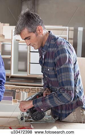 Man cutting a piece of wood View Large Photo Image Stock Photo - Man cutting a piece of wood. Fotosearch