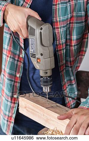 Man drilling wood View Large Photo Image Stock Photograph - Man drilling wood. Fotosearch