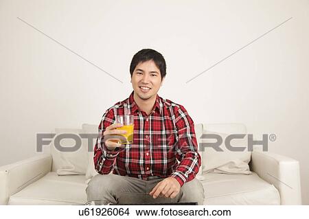 Picture - Man drinking a juice. Fotosearch