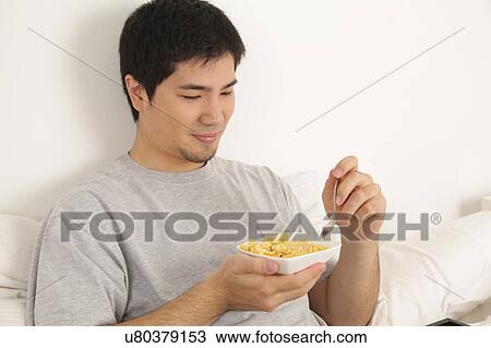 Stock Image - Man eating cereals. Fotosearch