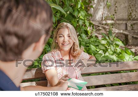 Man giving a card to his girlfriend View Large Photo Image Stock Photo - Man giving a card to his girlfriend. Fotosearch