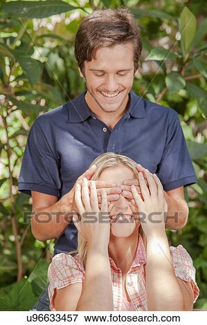 Man giving a surprise to his girlfriend View Large Photo Image Stock Photo - Man giving a surprise to his girlfriend. Fotosearch