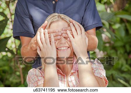 Stock Photography - Man giving a surprise to his girlfriend. Fotosearch