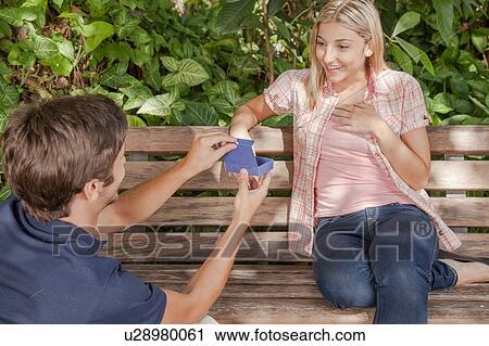 Man giving to his girlfriend a surprice View Large Photo Image Stock Image - Man giving to his girlfriend a surprice. Fotosearch