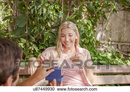 Man giving to his girlfriend a surprice View Large Photo Image Stock Image - Man giving to his girlfriend a surprice. Fotosearch