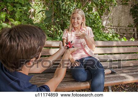 Stock Photo - Man giving to his girlfriend a surprice. Fotosearch