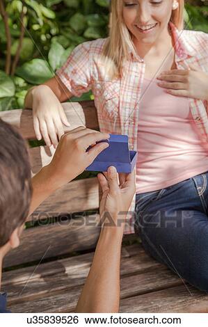 Man giving to his girlfriend a surprice View Large Photo Image Stock Photograph - Man giving to his girlfriend a surprice. Fotosearch