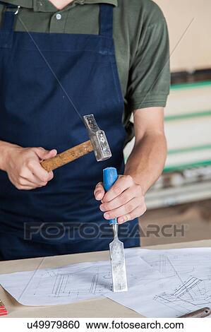 Stock Image - Man hammering. Fotosearch