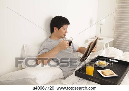 Man having a breakfast while reading the newspaper View Large Photo Image Stock Image - Man having a breakfast while reading the newspaper. Fotosearch