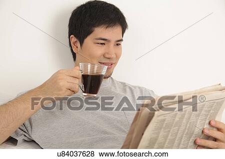 Man having a breakfast while reading the newspaper View Large Photo Image Stock Photo - Man having a breakfast while reading the newspaper. Fotosearch