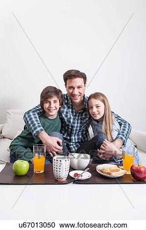 Man having a breakfast with your two childrens View Large Photo Image Stock Image - Man having a breakfast with your two childrens. Fotosearch