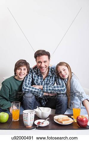 Man having a breakfast with your two childrens View Large Photo Image Stock Image - Man having a breakfast with your two childrens. Fotosearch