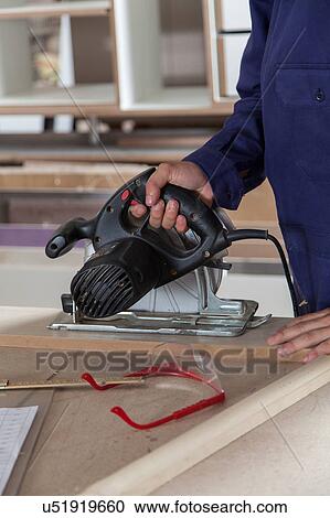 Stock Image - Man hoding a electric saw. Fotosearch