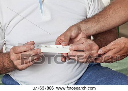 Stock Photograph - Man holdin a pillbox. Fotosearch