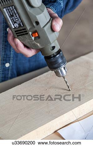 Stock Image - Man holding a drill. Fotosearch