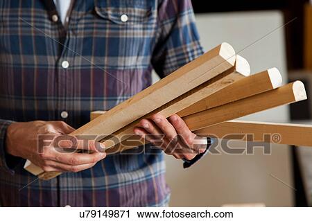 Stock Image - Man holding a pieces of wood. Fotosearch