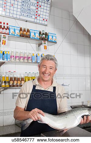 Stock Photo - Man holding a pink salmon. Fotosearch