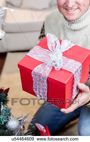 Stock Photo - Man holding a red giftbox. Fotosearch