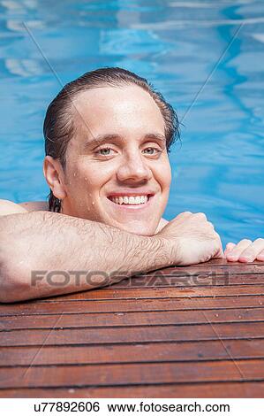 Stock Photograph - Man in the edge of the pool. Fotosearch
