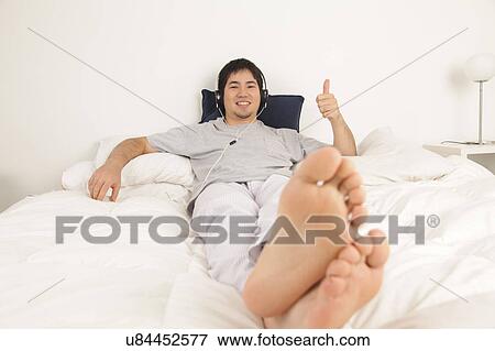 Man listening music lying View Large Photo Image Stock Photo - Man listening music lying. Fotosearch