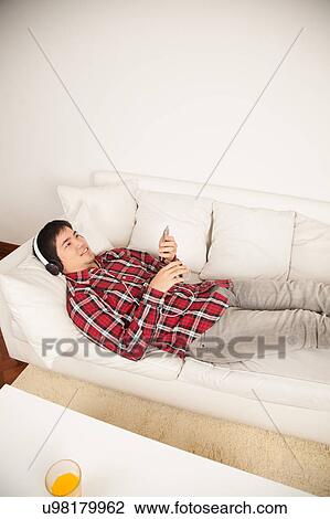 Man listening to music and lying View Large Photo Image Stock Image - Man listening to music and lying. Fotosearch
