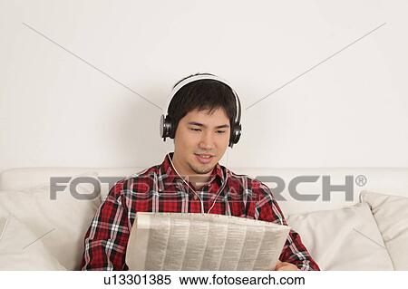 Man listening to music and reading the newspaper View Large Photo Image Stock Photography - Man listening to music and reading the newspaper. Fotosearch